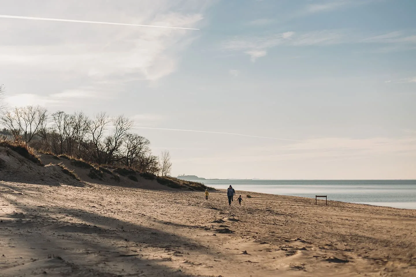 Family walking on the beach in winter