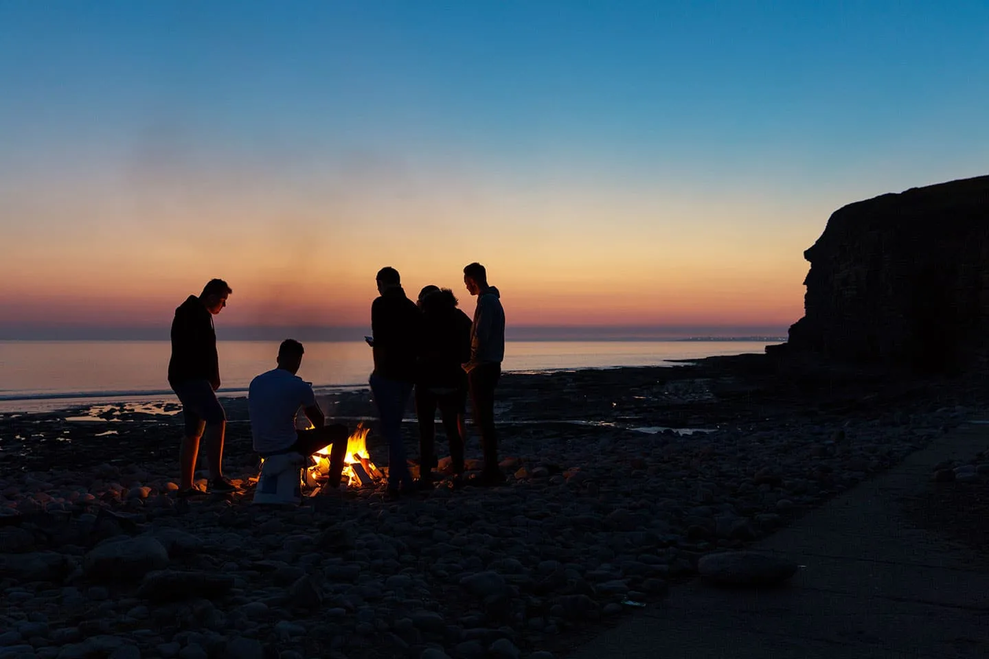 Group of people making bonfire at the beach