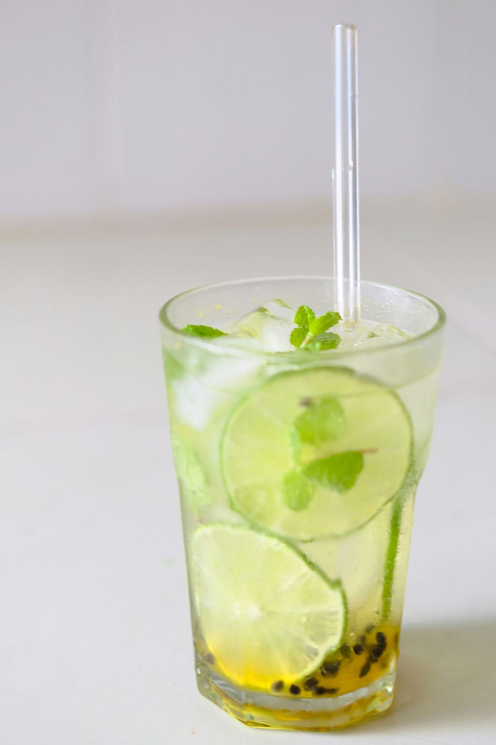 icy drink with mint, lime and passionfruit in plastic glass