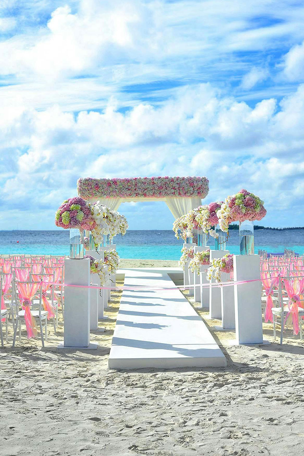 beach wedding venue decorated with soft pink and light yellow flowers