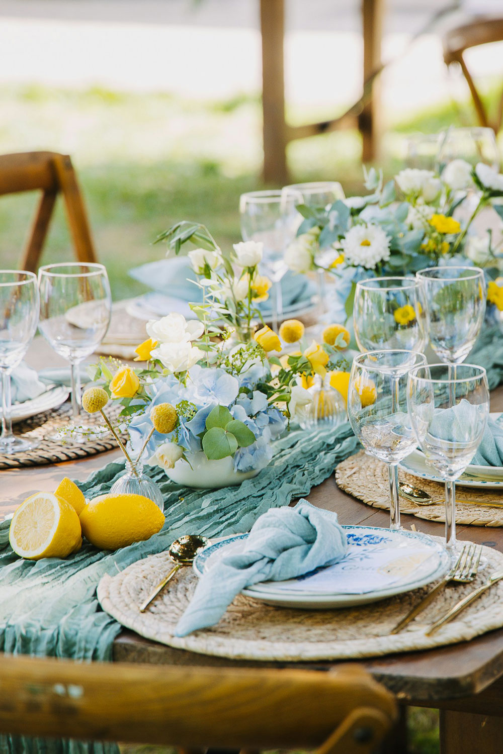 table setting with white daisies and yellow flowers complemented by lemons