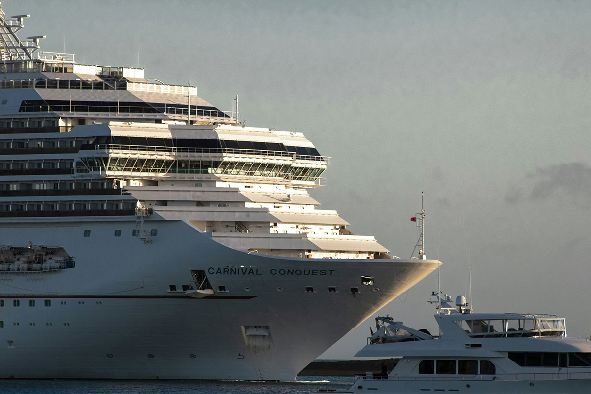 Carnival Conquest cruise ship in a port next to a smaller ship