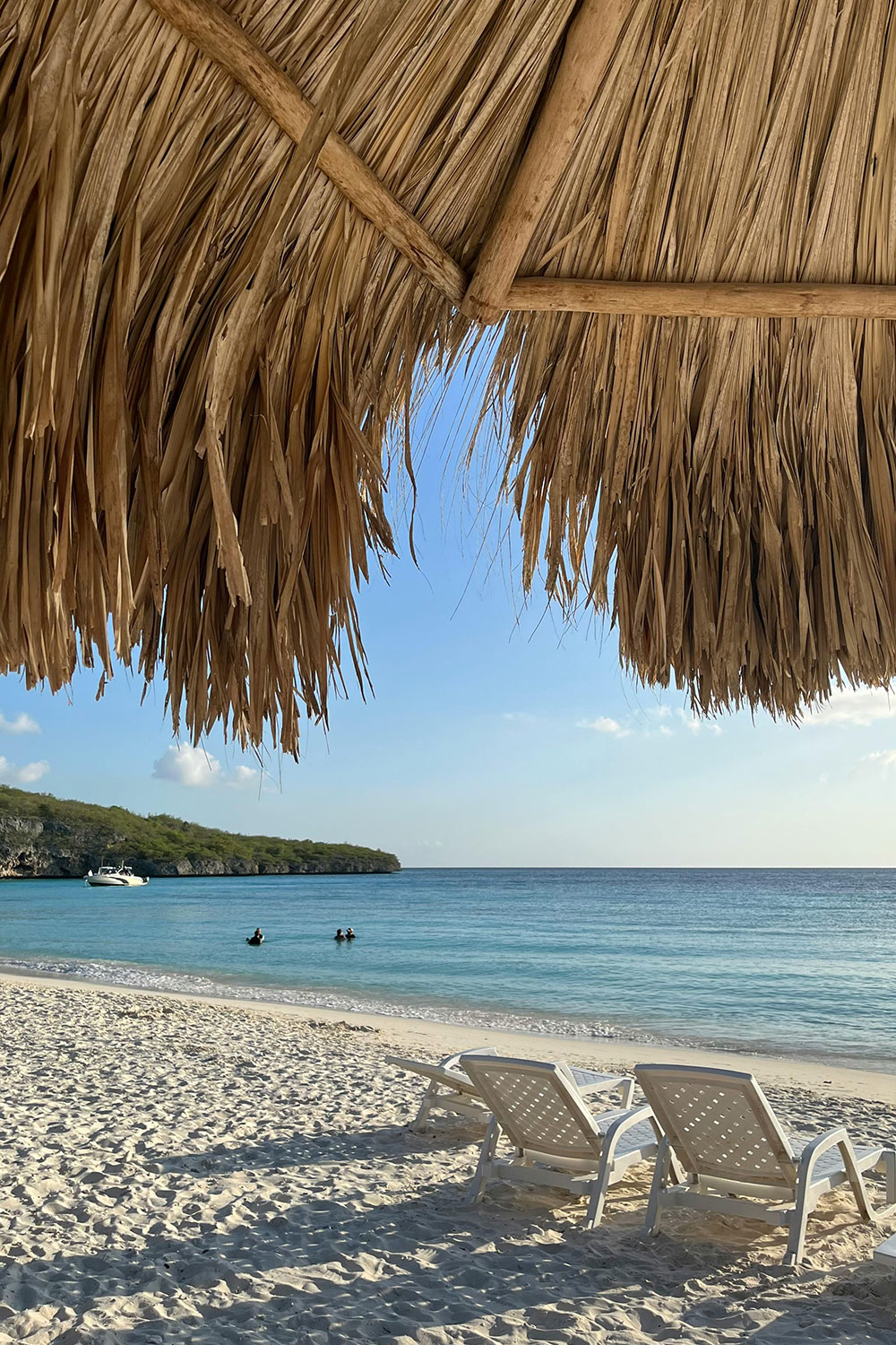 beach scene on Cas Abao Beach with lounge chairs and Umbrella near the sea