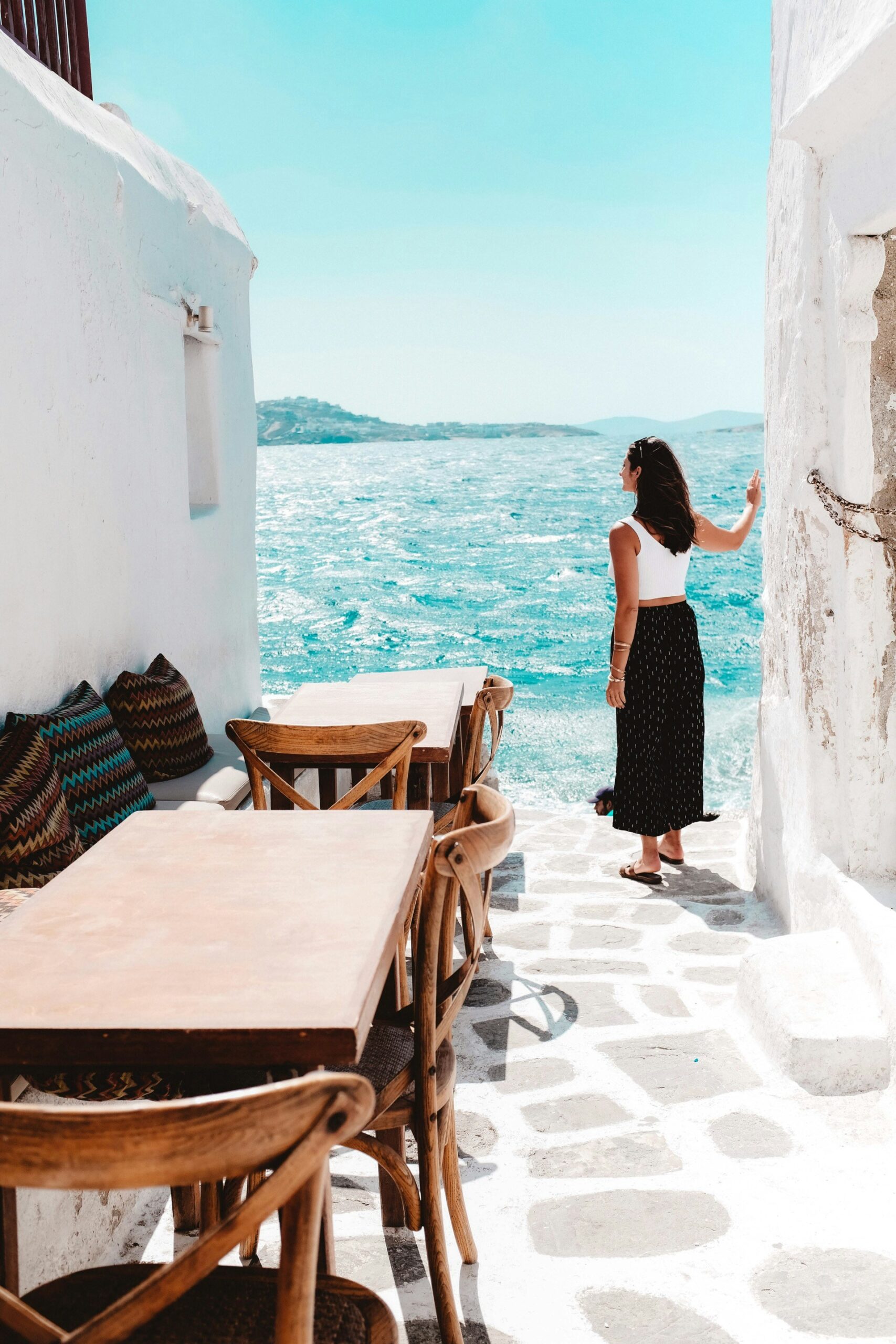 woman standing on picturesque alleyway near the sea in Mykonos