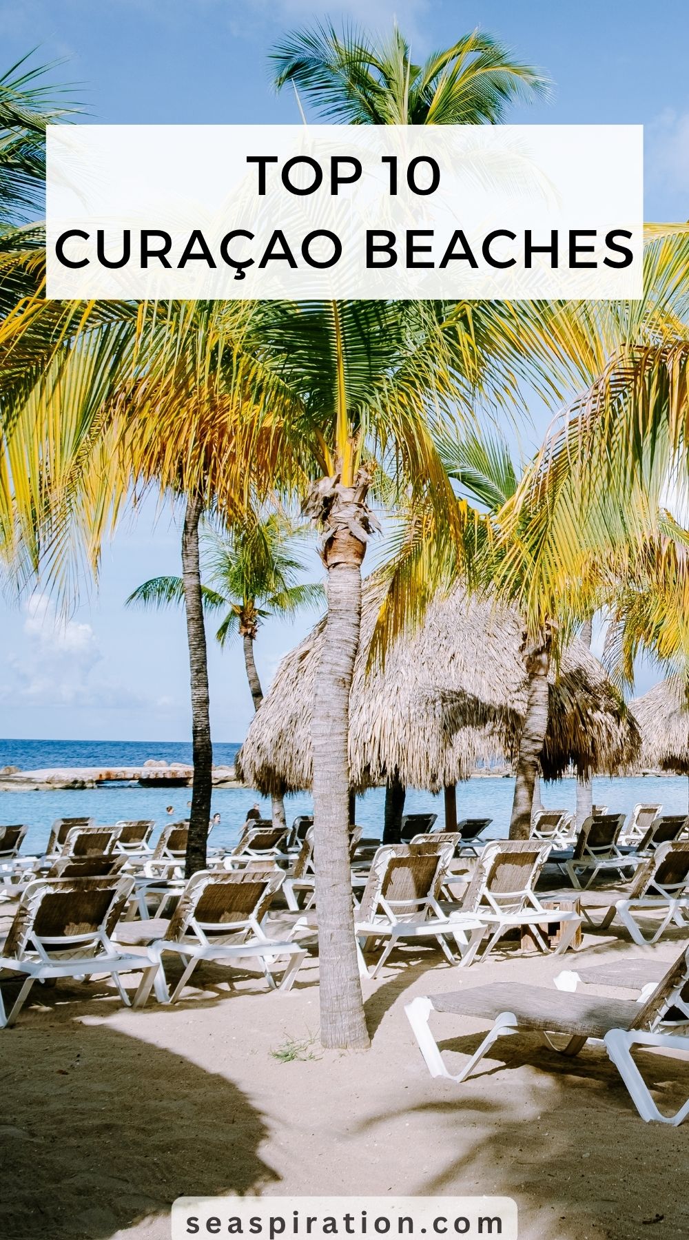 sunbeds under palm trees along the calm lagoon of Mambo beach