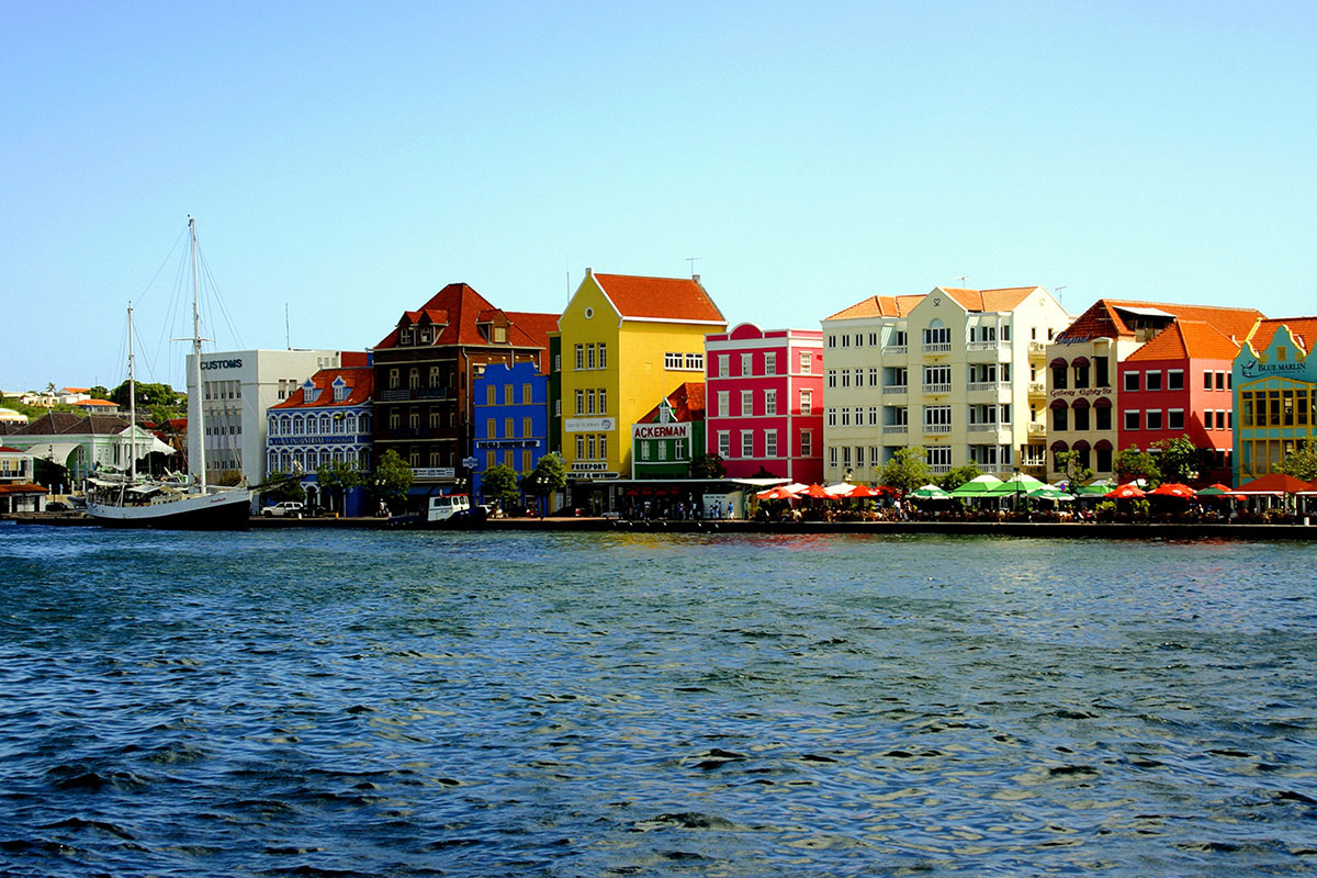 the waterfront of Willemstad, the capital city of Curaçao with colorful houses lined by the sea