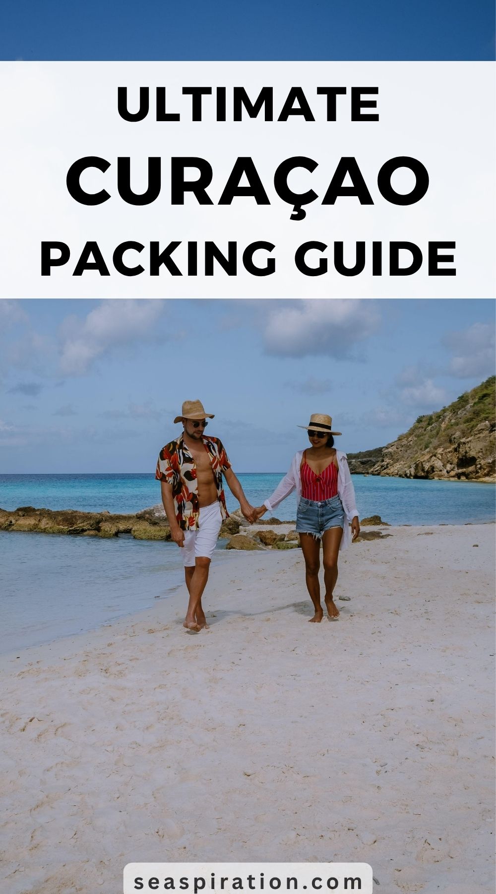 couple holding hands walking on a sandy beach on  Curaçao