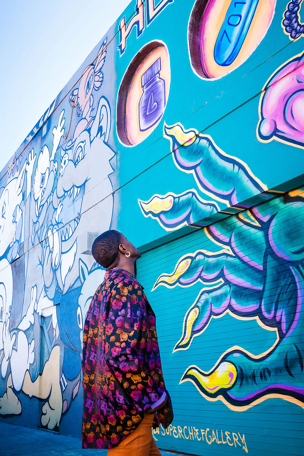 man looking at colorful graffiti art on a wall in Wynwood, Miami
