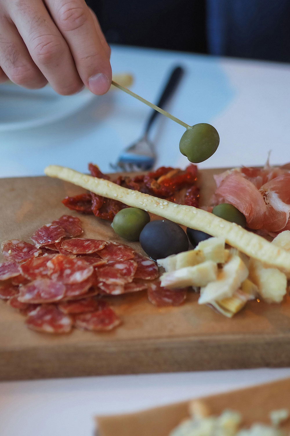 close-up of a charcuterie board featuring olives, cured meats, and cheeses